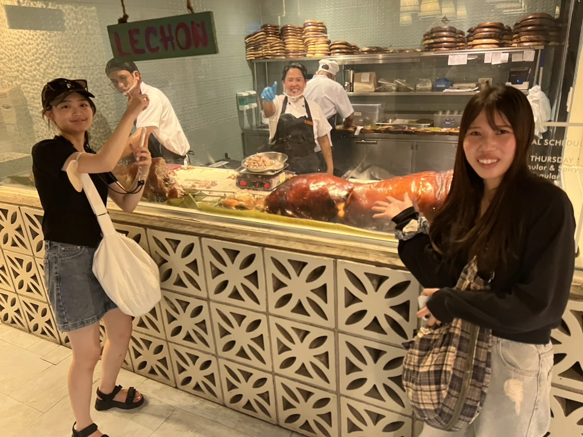 ハウスオブレチョンのLECHONの看板と丸焼きの前で写真を撮るお客様