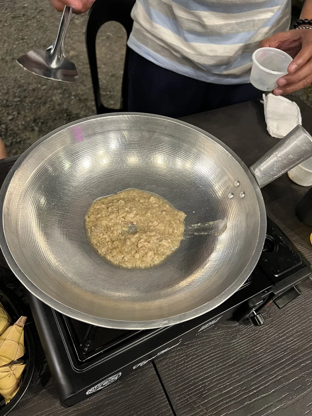 鉄鍋に入れられた炒める前の豚の脳みそ。粒が残っていてペースト状ではない