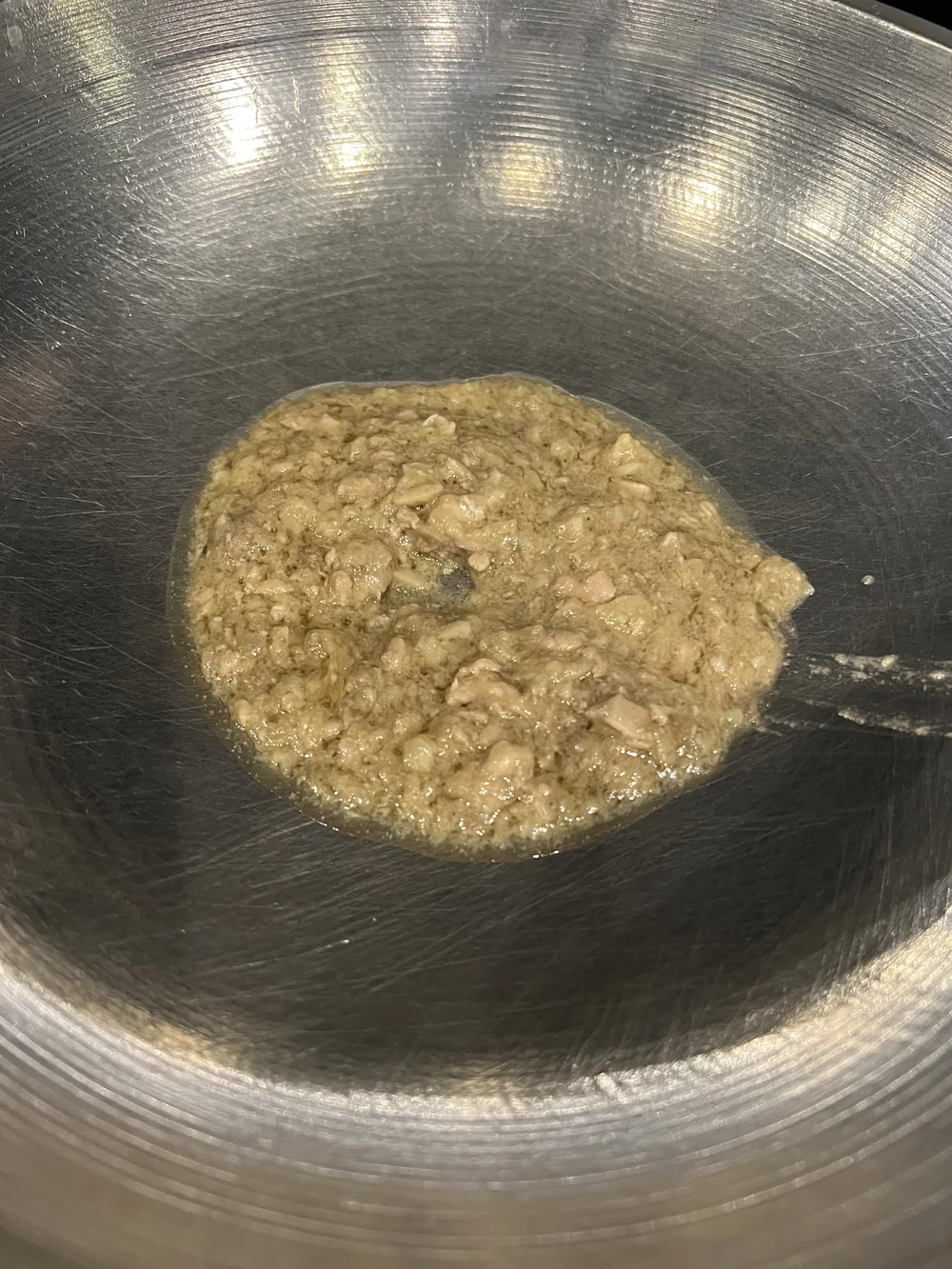 鉄鍋の中のトゥスロブワのアップ。豆腐を崩したような粒感のある質感