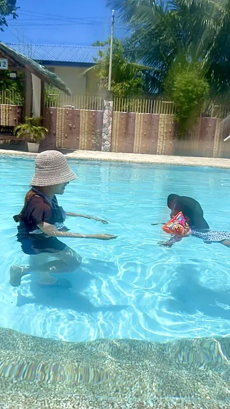 オランゴ島のプールで浮き輪をつけた2歳の子どもと遊ぶお母様