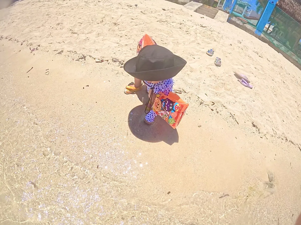 オランゴ島のビーチの砂浜で遊ぶ2歳の子ども