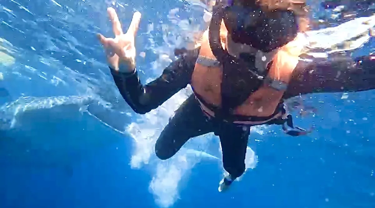 オスロブの海中でピースをするシュノーケラー