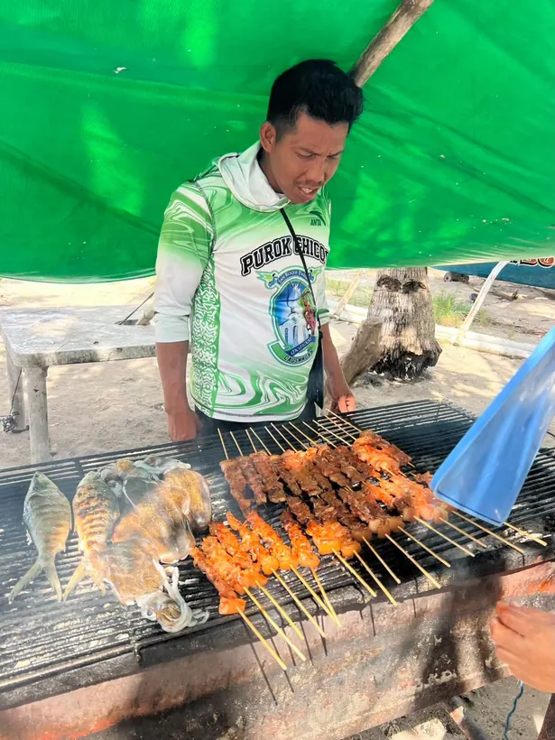 グリルの前でBBQを焼き上げるスタッフ